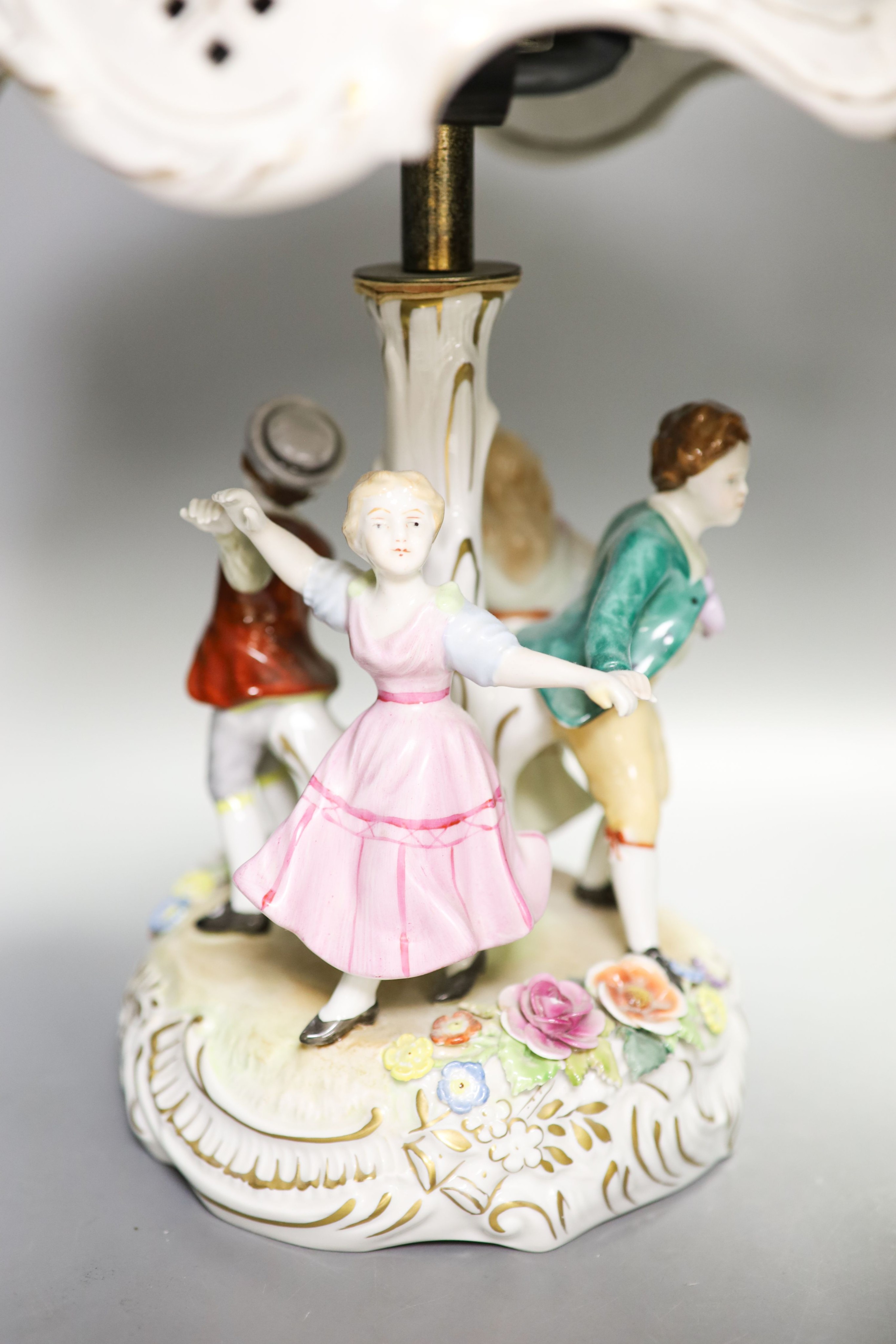 Two pairs of German porcelain table lamps, the stems modelled with figures dancing 56cm